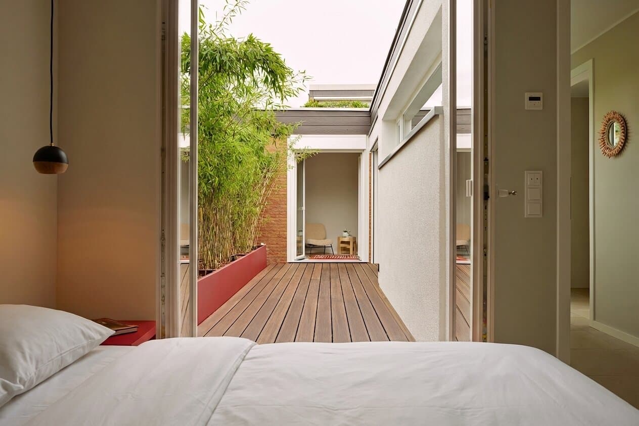 Master bedroom Bungalow Ratingen, double bed with view through sliding doors onto the private bamboo courtyard