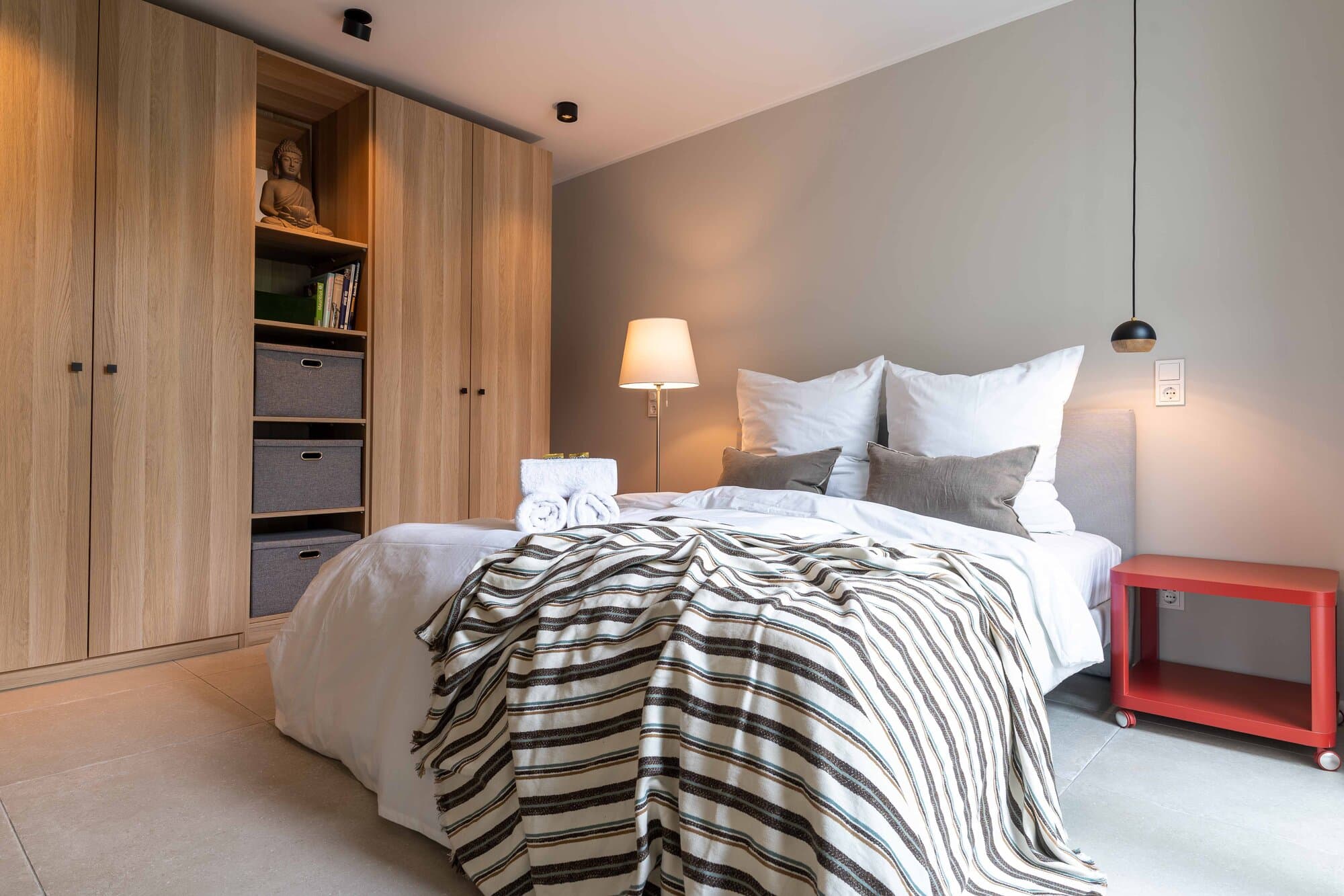 Master bedroom with a 160 × 200 cm double bed, oak wardrobe wall and a striped wool throw